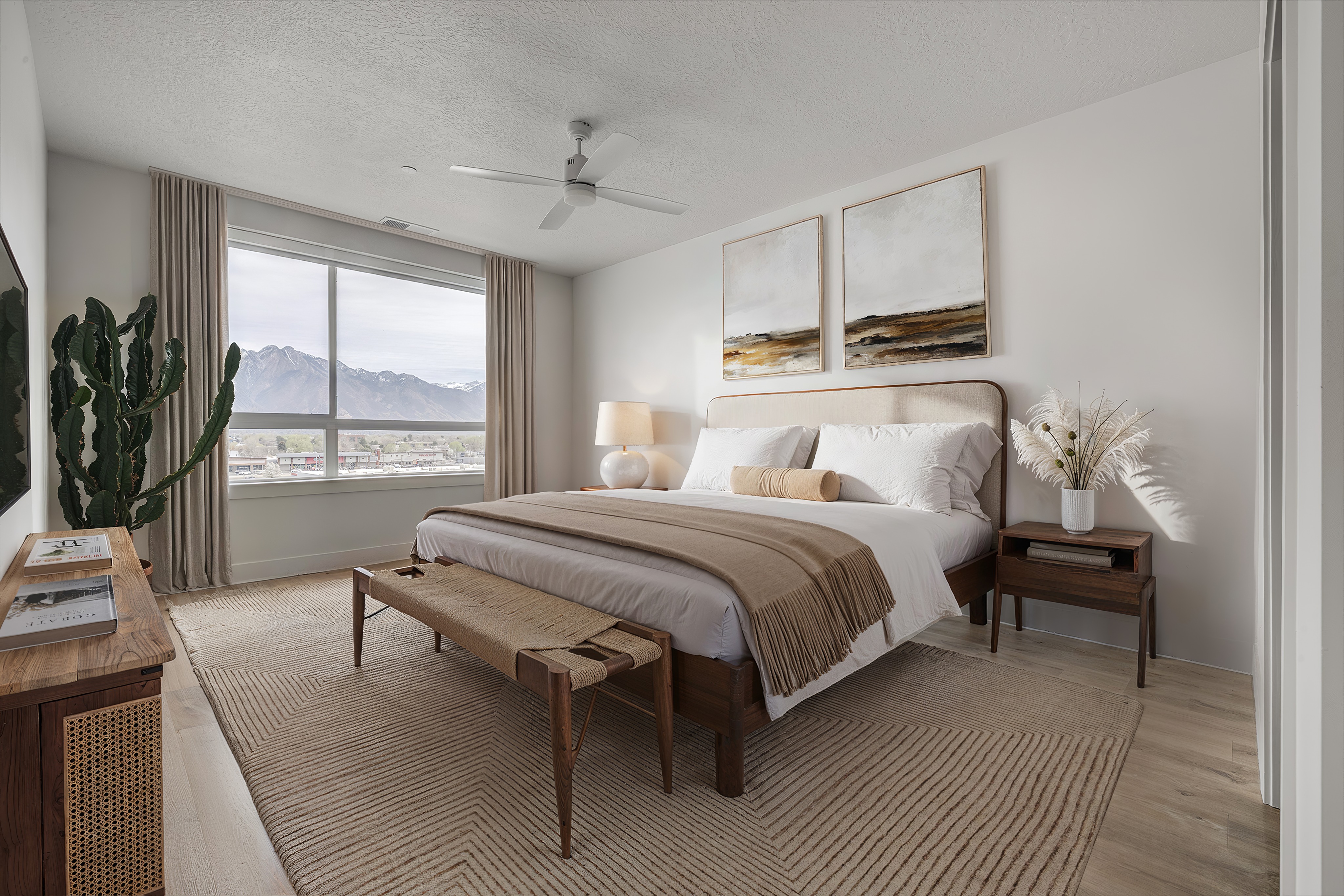 A bedroom with a large bed and a cactus plant.